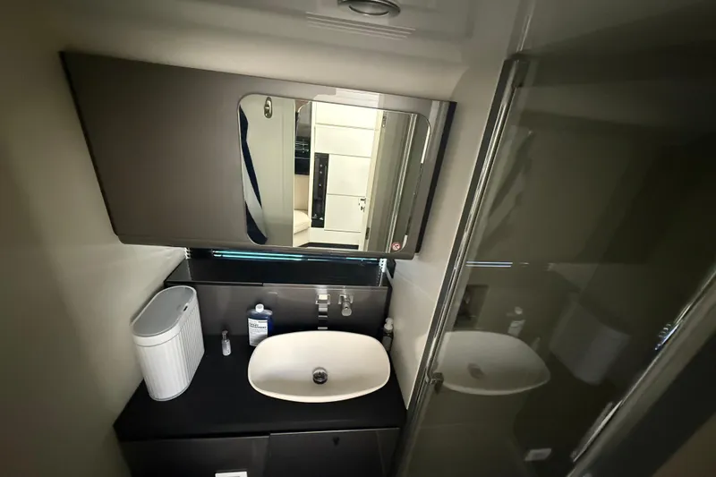 Chicken Money Yacht Photos Pics Modern bathroom interior of 2023 Azimut Verve 47 yacht, featuring sleek sink and mirror.