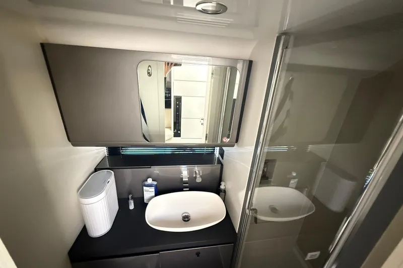 Chicken Money Yacht Photos Pics Modern bathroom interior of 2023 Azimut Verve 47 yacht, featuring sleek sink and mirror.