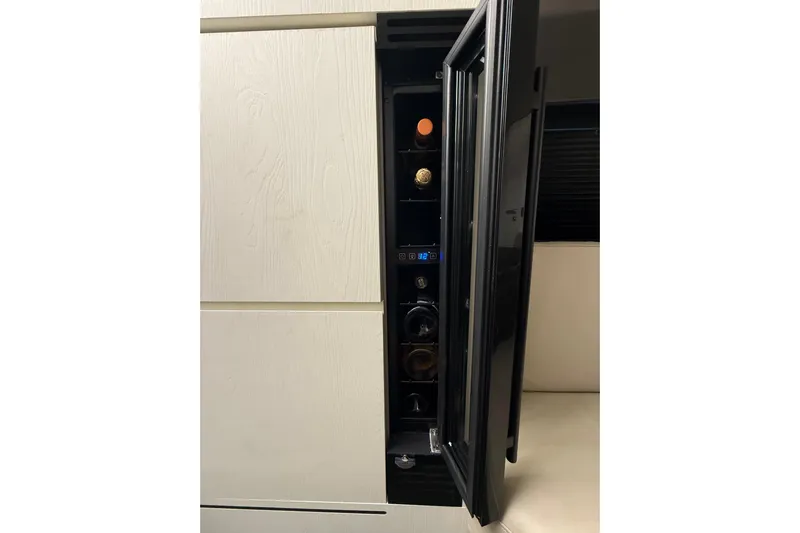 Chicken Money Yacht Photos Pics Wine cooler inside 2023 Azimut Verve 47 yacht, partially open with bottles visible.