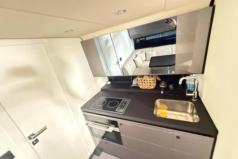 Chicken Money Yacht Photos Pics Modern kitchen interior of 2023 Azimut Verve 47 yacht with sleek design and amenities.