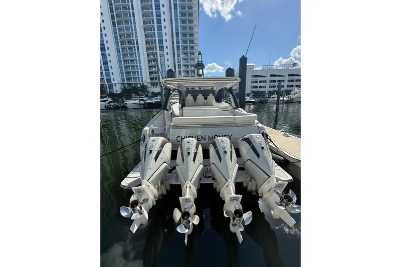 Chicken Money Yacht Photos Pics 2023 Azimut Verve 47 yacht with four powerful outboard engines docked in a marina.