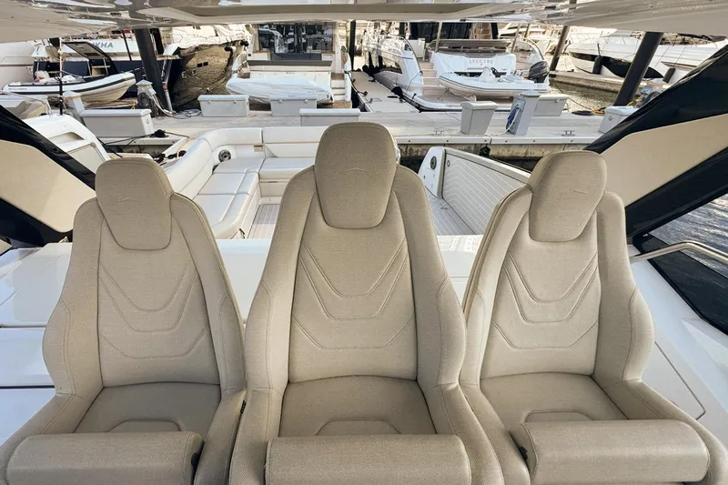 Chicken Money Yacht Photos Pics Three beige seats on 2023 Azimut Verve 47 yacht, docked at marina.