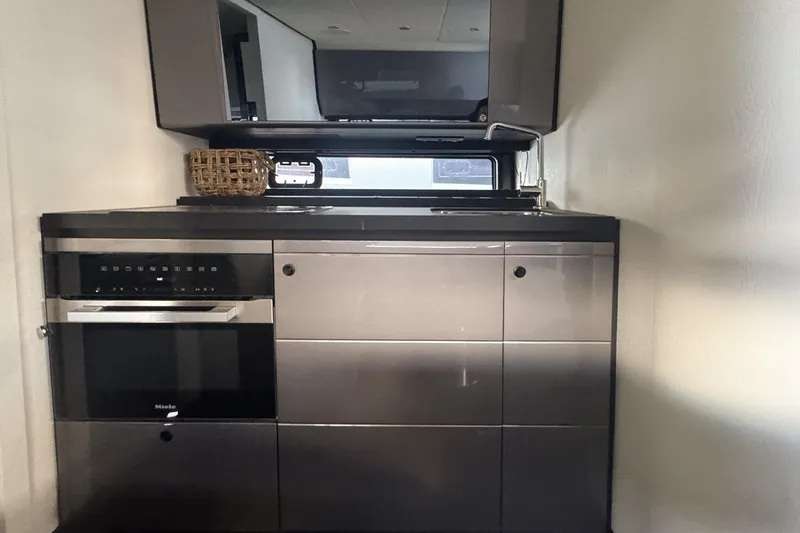 Chicken Money Yacht Photos Pics Modern kitchen interior on 2023 Azimut Verve 47 yacht, featuring sleek cabinetry and appliances.