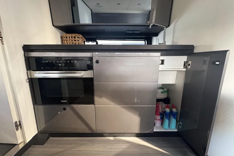 Chicken Money Yacht Photos Pics Modern kitchen interior of 2023 Azimut Verve 47 yacht with sleek cabinetry and appliances.