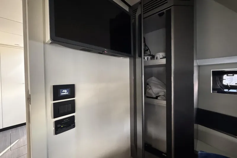 Chicken Money Yacht Photos Pics 2023 Azimut Verve 47 interior with TV, control panels, and storage shelves.