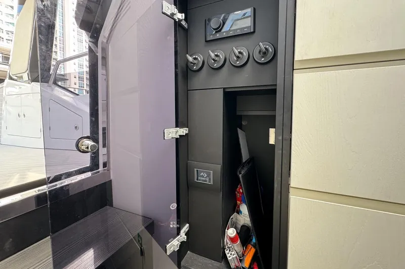 Chicken Money Yacht Photos Pics 2023 Azimut Verve 47 yacht interior storage compartment with control panel and accessories.