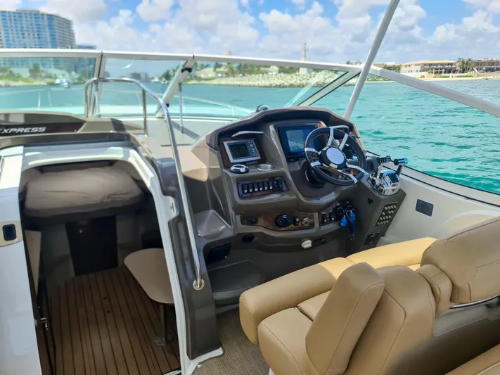  Yacht Photos Pics 2015 Cruisers Yachts 350 Express helm with modern controls, overlooking turquoise waters.