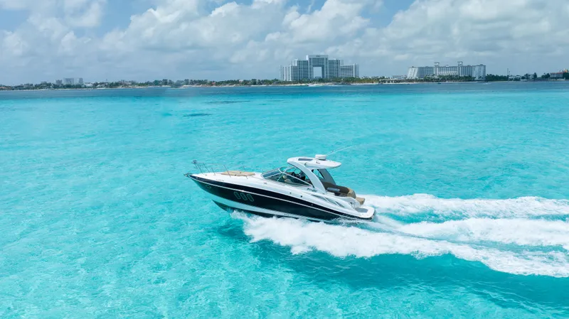  Yacht Photos Pics 2015 Cruisers Yachts 350 Express cruising on turquoise waters under a partly cloudy sky.