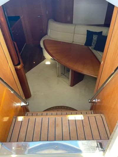  Yacht Photos Pics Interior of 2005 Sunseeker Portofino 53 yacht with wooden table and cream sofa.