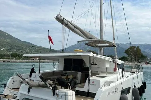 Love Is Yacht Photos Pics 2019 Fountaine Pajot Lucia 40 Maestro catamaran docked with scenic mountain backdrop.