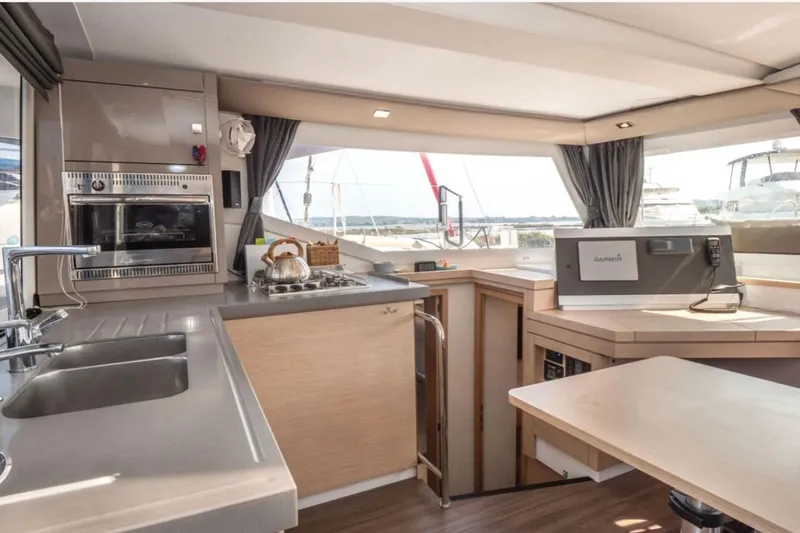 Love Is Yacht Photos Pics Interior of 2019 Fountaine Pajot Lucia 40 Maestro catamaran, featuring modern kitchen and navigation area.