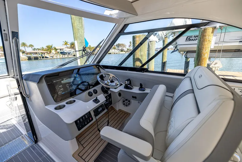 Absolutely Knot Yacht Photos Pics 2022 Regal LX36 boat interior with modern helm, steering wheel, and waterfront view.