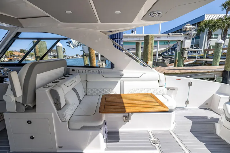 Absolutely Knot Yacht Photos Pics Luxurious 2022 Regal LX36 yacht interior with elegant seating and wooden table at marina.