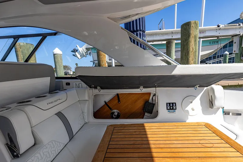 Absolutely Knot Yacht Photos Pics 2022 Regal LX36 boat interior with seating, wooden table, and storage compartment.