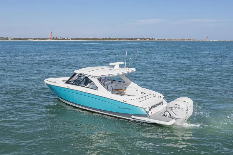 Absolutely Knot Yacht Photos Pics 2022 Regal LX36 boat cruising on open water with distant shoreline.