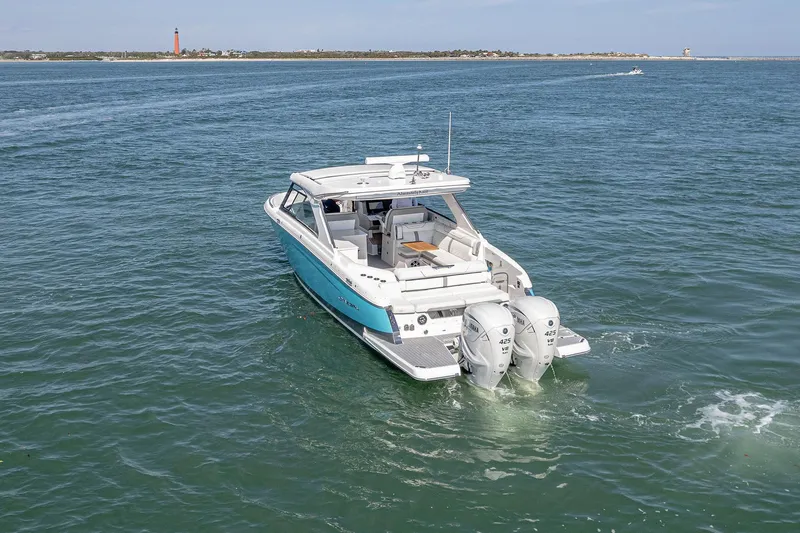 Absolutely Knot Yacht Photos Pics 2022 Regal LX36 boat cruising on open water with twin engines.