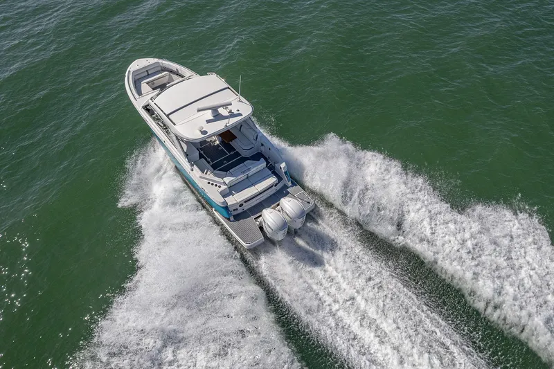 Absolutely Knot Yacht Photos Pics 2022 Regal LX36 boat cruising on open water, aerial view.
