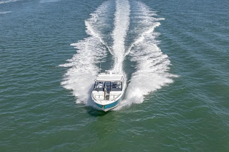 Absolutely Knot Yacht Photos Pics 2022 Regal LX36 boat cruising on open water, leaving a wake trail.