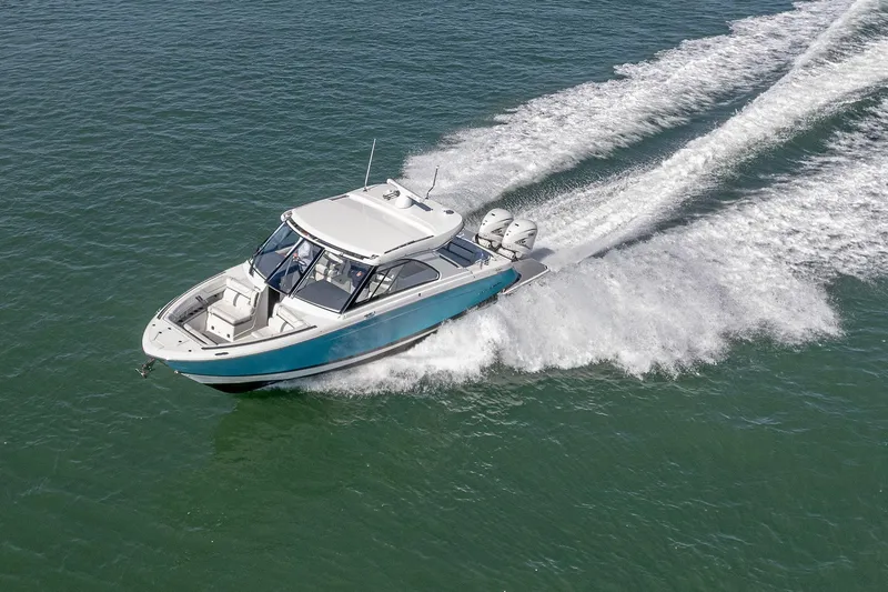 Absolutely Knot Yacht Photos Pics 2022 Regal LX36 boat cruising on open water, creating a dynamic wake.