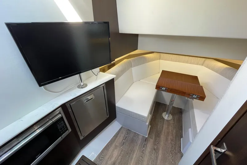  Yacht Photos Pics 2023 Cruisers Yachts 38 GLS I/O interior with TV, seating, and table.