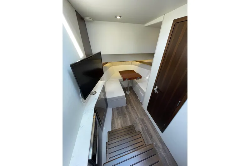  Yacht Photos Pics 2023 Cruisers Yachts 38 GLS I/O interior with modern seating, TV, and wooden flooring.