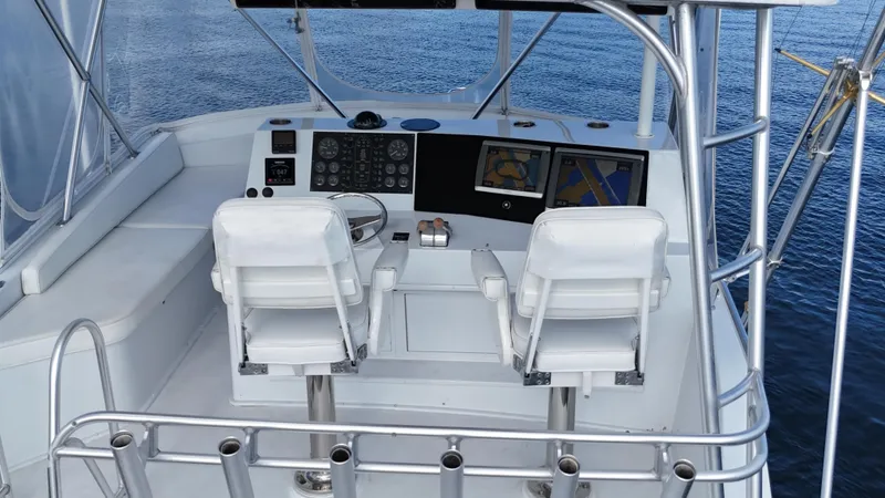  Yacht Photos Pics 1999 Viking 47 Convertible yacht helm with dual white captain chairs and navigation equipment.