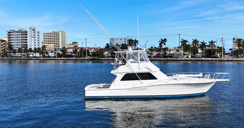  Yacht Photos Pics 1999 Viking 47 Convertible yacht on calm water with cityscape background.