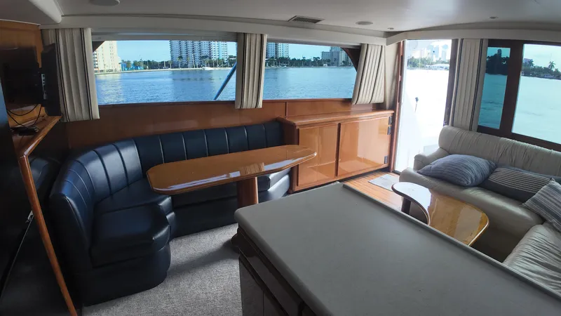  Yacht Photos Pics Interior of 1999 Viking 47 Convertible yacht with waterfront view, featuring seating and table.