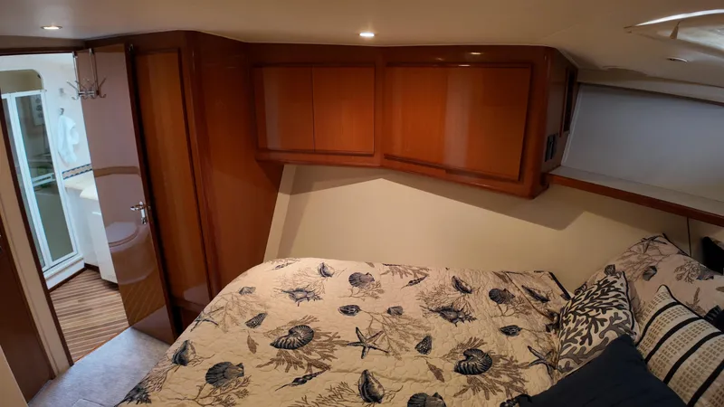  Yacht Photos Pics Cozy bedroom in 1999 Viking 47 Convertible yacht with nautical-themed bedding.