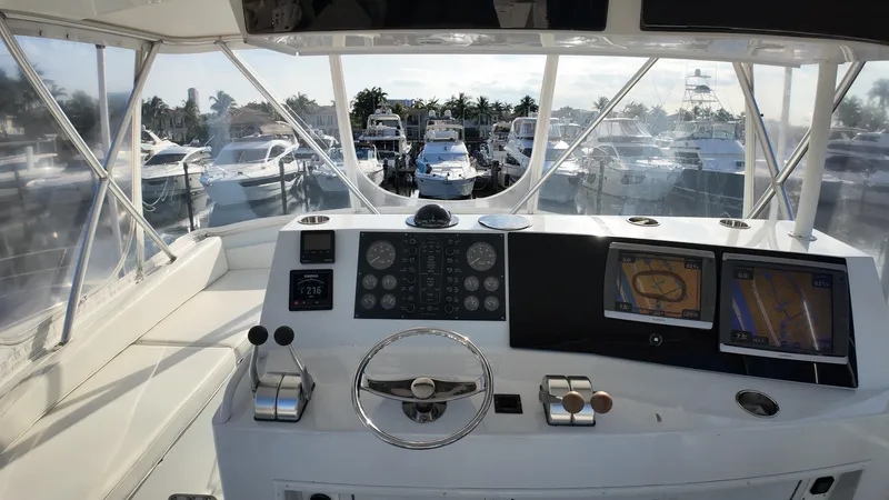  Yacht Photos Pics 1999 Viking 47 Convertible yacht helm with navigation screens and marina view.