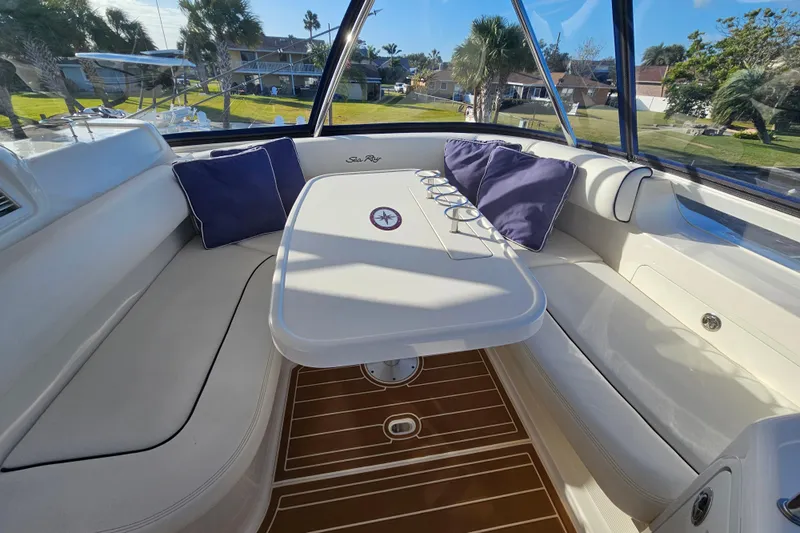 Low Hours! Yacht Photos Pics Luxurious interior of 2006 Sea Ray 580 Sedan Bridge with cushioned seating and table.