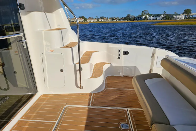Low Hours! Yacht Photos Pics 2006 Sea Ray 580 Sedan Bridge yacht deck with elegant wood finish and scenic water view.
