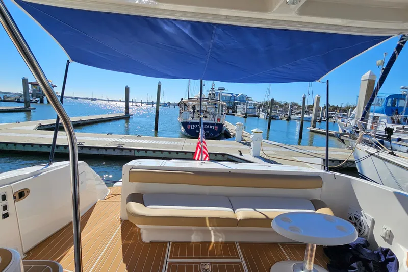 Low Hours! Yacht Photos Pics 2006 Sea Ray 580 Sedan Bridge yacht docked, featuring a shaded seating area and marina view.