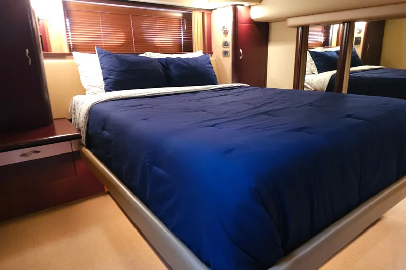 Low Hours! Yacht Photos Pics Luxurious bedroom interior of 2006 Sea Ray 580 Sedan Bridge yacht with blue bedding.