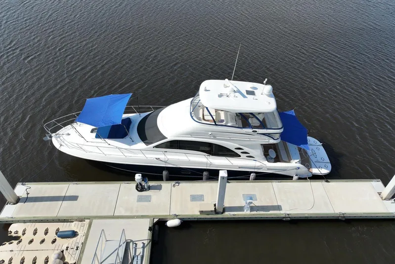 Low Hours! Yacht Photos Pics 2006 Sea Ray 580 Sedan Bridge yacht docked, featuring blue sunshades and sleek design.