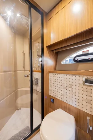 Andiamo Yacht Photos Pics Luxurious bathroom in 2017 Sea Ray 59 Flybridge yacht with modern shower and wooden accents.