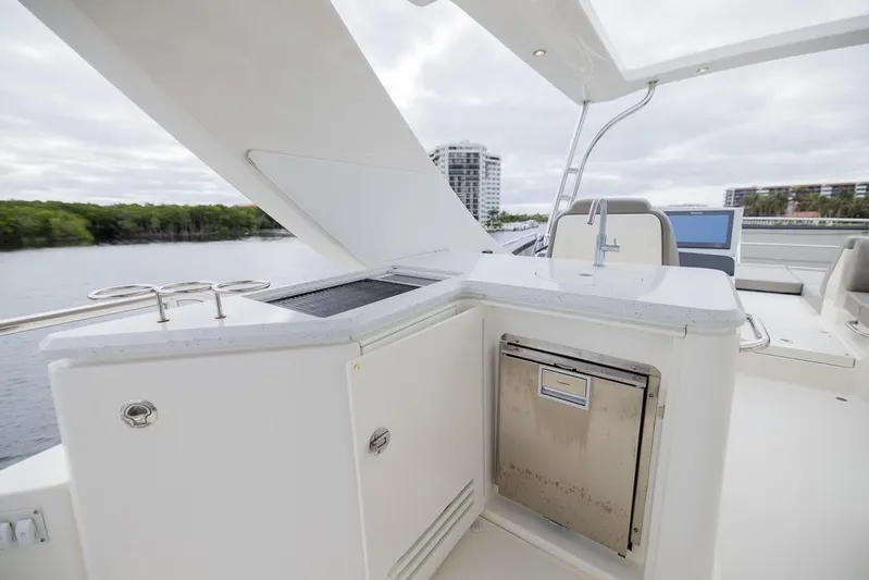 Andiamo Yacht Photos Pics 2017 Sea Ray 59 Flybridge yacht with outdoor kitchen and scenic waterfront view.