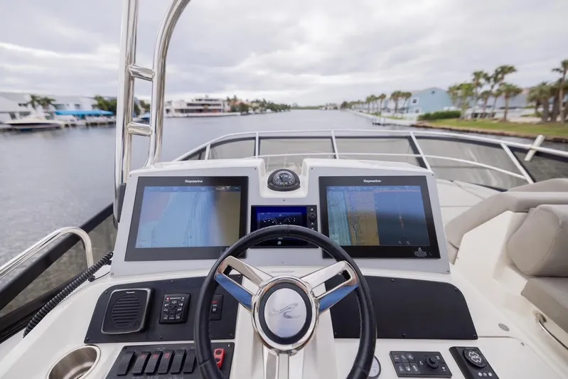 Andiamo Yacht Photos Pics 2017 Sea Ray 59 Flybridge helm with dual navigation screens on a calm waterway.