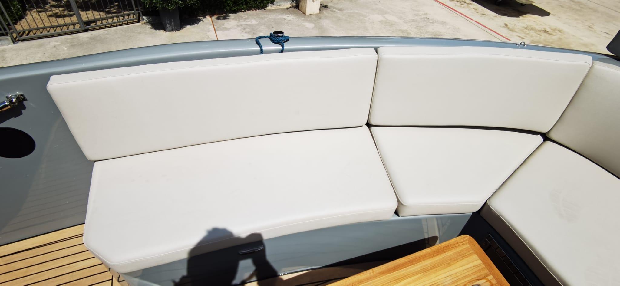 White cushioned seating on Rand PLAY 24 boat, 2022 model, with wooden deck detail.