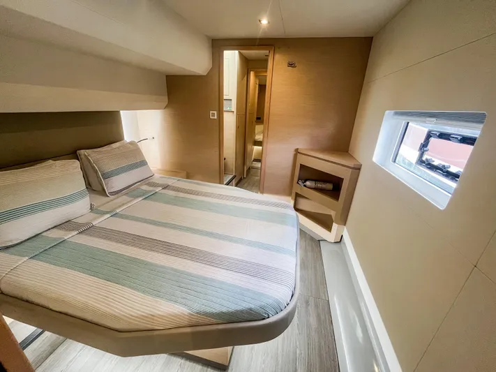  Yacht Photos Pics Cozy cabin interior of 2020 Fountaine Pajot MY 44 with striped bedding and window view.