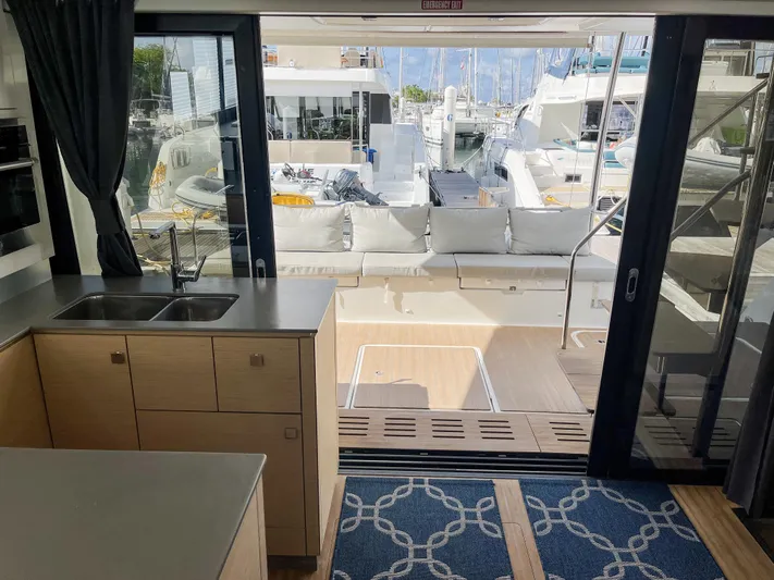  Yacht Photos Pics Interior view of 2020 Fountaine Pajot MY 44 yacht, featuring kitchen and outdoor seating area.