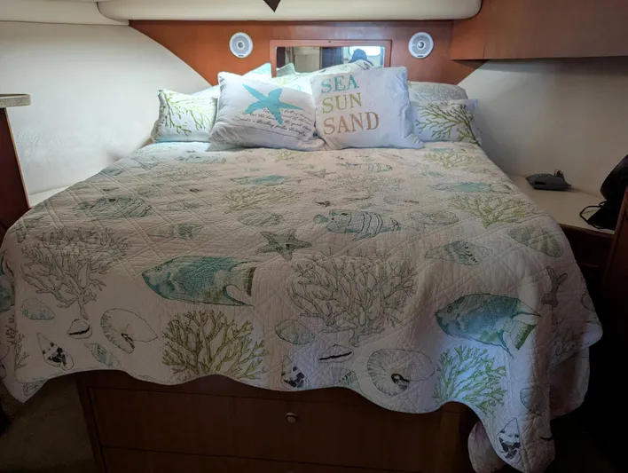  Yacht Photos Pics Cozy bedroom in 2005 Luhrs 36 Convertible with ocean-themed bedding and decorative pillows.