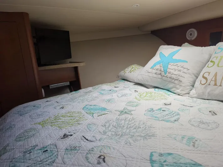  Yacht Photos Pics Cozy cabin interior of 2005 Luhrs 36 Convertible with nautical-themed bedding and TV.