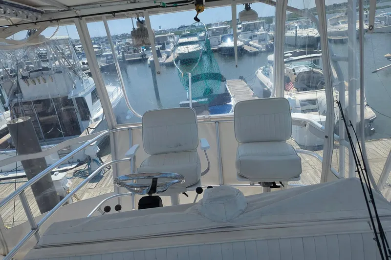  Yacht Photos Pics 2005 Luhrs 36 Convertible boat interior with marina view, featuring helm and seating.