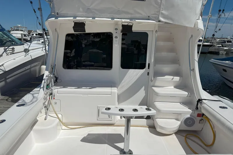  Yacht Photos Pics 2005 Luhrs 36 Convertible yacht cockpit with fishing rod holders and docked boats in background.