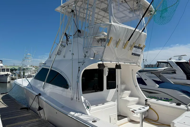 Yacht Photos Pics 2005 Luhrs 36 Convertible yacht docked, featuring a spacious deck and fishing equipment.