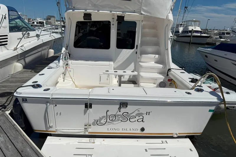 Yacht Photos Pics 2005 Luhrs 36 Convertible boat docked at marina, featuring spacious deck and white exterior.