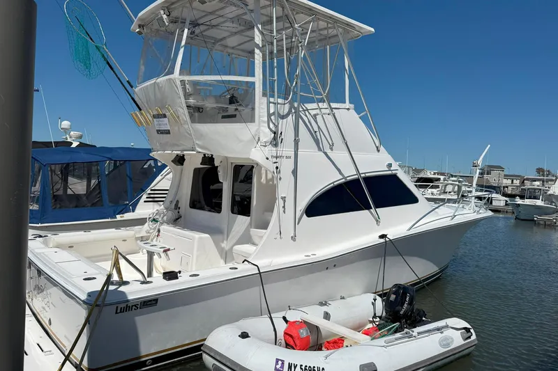  Yacht Photos Pics 2005 Luhrs 36 Convertible yacht docked at marina, featuring fishing equipment and inflatable boat.