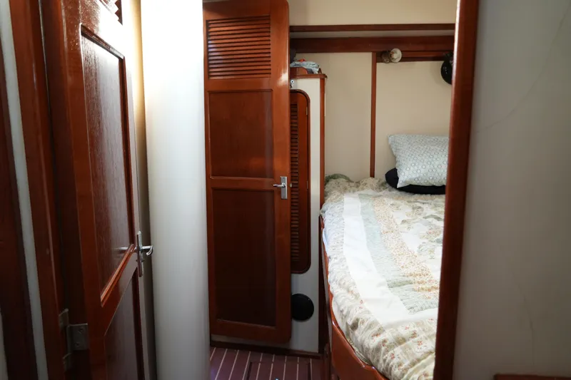 Peggy Lee Yacht Photos Pics Cozy cabin interior of 1984 Irwin 52 Cutter Ketch with wooden finishes and bed.
