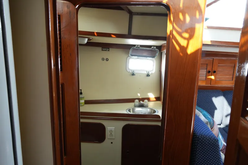 Peggy Lee Yacht Photos Pics Interior of 1984 Irwin 52 Cutter Ketch, featuring wooden cabinetry and compact sink area.